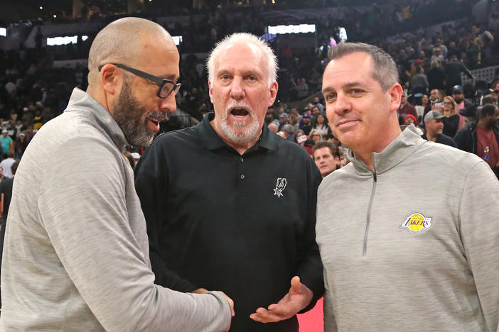 Head coach Gregg Popovich of the San Antonio Spurs, center, is congratulated by head coach Frank Vogel, right, and assistant coach David Fizdale, left, of the Los Angeles Lakers after Popovich tied the NBA record for all-time wins of 1,335 by an NBA head coach.
