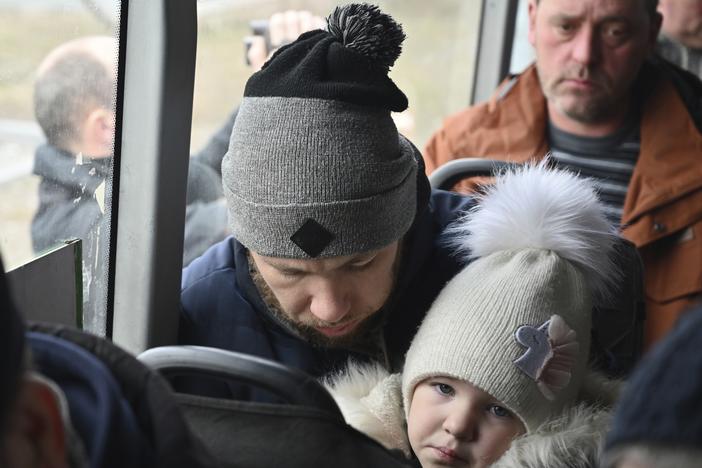 Refugees fleeing the military operation zone from the Mariupol area of Ukraine sit in a bus as they arrive at the border crossing in Veselo-Voznesenka, Russia, on Monday.