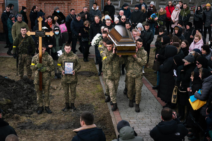 Tuesday's funeral procession ends at the gravesites where soldiers Viktor Dudar, 44, and Ivan Koverznev, 24, will be buried as priests say their blessings and mourners look on.