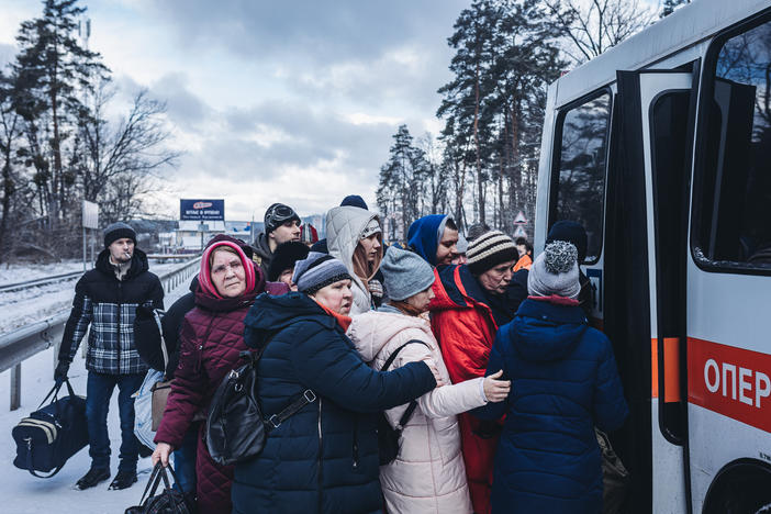 People board an evacuation bus as civilians continue to flee Russian attacks in Irpin, Ukraine, on Tuesday.