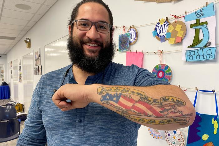 Rafael Rivera's tattoo of an American Flag in the shape of Long Island, with a banner from John 15:13.