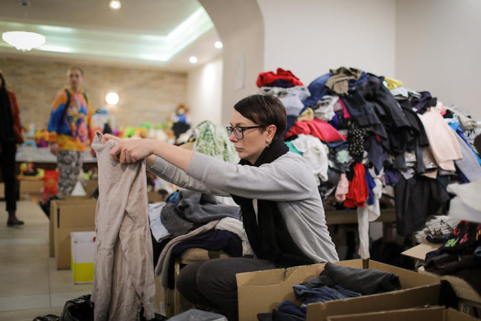 A volunteer at the hotel sorts donated clothing.