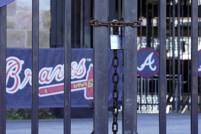 Locked gates are shown at Truist Park home of the Atlanta Braves baseball team Wednesday, March 2, 2022, in Atlanta. Negotiators for locked-out players made their latest counteroffer to Major League Baseball on Wednesday.