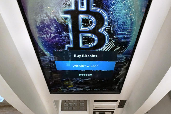 Bitcoin logo appears on the display screen of a cryptocurrency ATM at the Smoker's Choice store in Salem, N.H. (AP Photo/Charles Krupa, File)