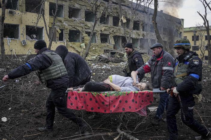 Ukrainian emergency employees and volunteers carry an injured pregnant woman from a maternity hospital that was severely damaged by shelling in Mariupol, Ukraine, on Wednesday.