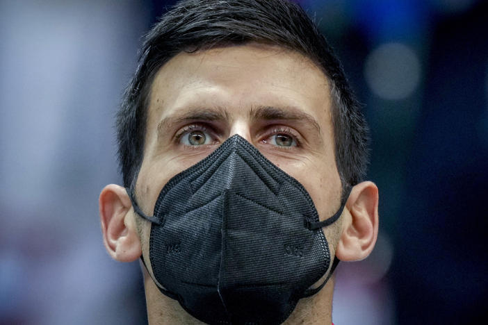 Serbia's Novak Djokovic wears a face mask as he listens to the national anthems prior to a Davis Cup group F match between Serbia and Austria in Innsbruck, Austria, on Nov. 26, 2021.