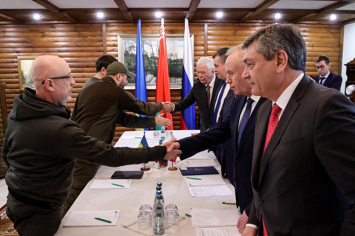Ukrainian Defense Minister Oleksii Reznikov (left) shakes hands with Russian negotiators prior to talks between their countries' delegations amid Russia's invasion of Ukraine, in Belarus' Brest region on March 3.