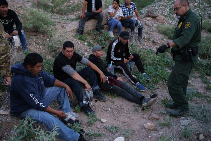 A U.S. Border Patrol agent processes a group of migrants in Sunland Park, New Mexico. Democratic lawmakers and immigrant advocates are urging President Biden to end Title 42 border restrictions.