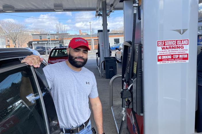 Argenis Dominguez fueling up his SUV at a gas station in Boston. He drives Uber for a living and says the higher gas prices mean less money in his pocket.