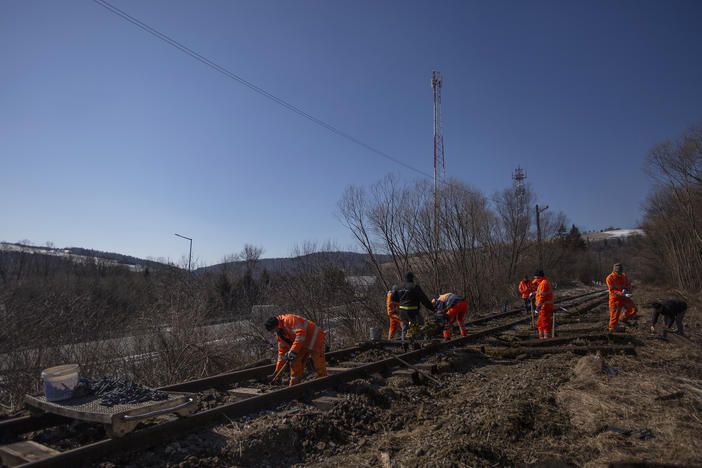 A crew of men repair an abandoned rail line that once connected this rural part of southern Poland to Ukraine.