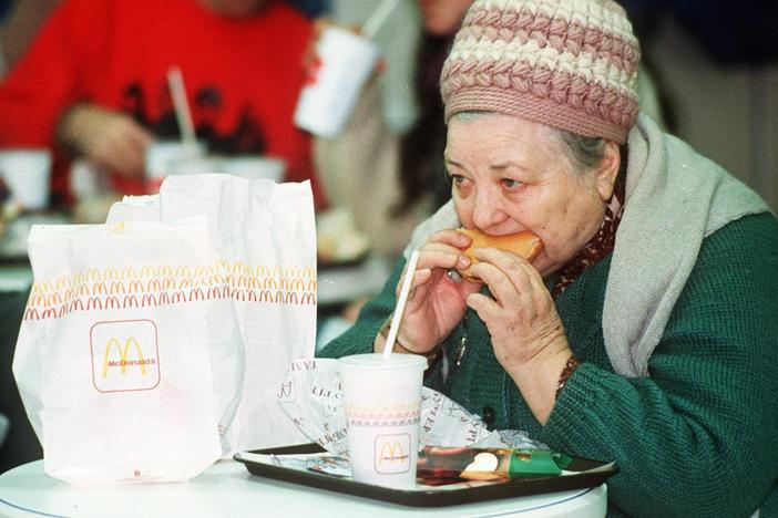 An elderly Russian woman eats a hamburger at the first McDonald's in the then Soviet Union on its opening day in January 1990.