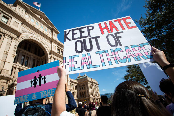 Demonstrators hold signs in support of transgender youth and rights in response to recent proposed legal action against parents seeking gender affirming healthcare for their children to be charged as child abuse at the Rally for Trans Youth at the Texas State Capitol earlier this month.
