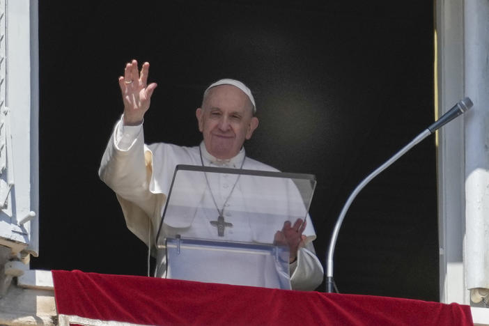 Pope Francis waves during the Angelus noon prayer from the window of his studio overlooking St. Peter's Square at the Vatican on Sunday.