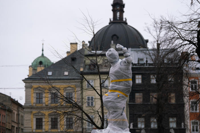 Statues wrapped in protective materials stand in Lviv's old quarter in western Ukraine. Officials are taking precautions to protect statues from being destroyed in Russian attacks.