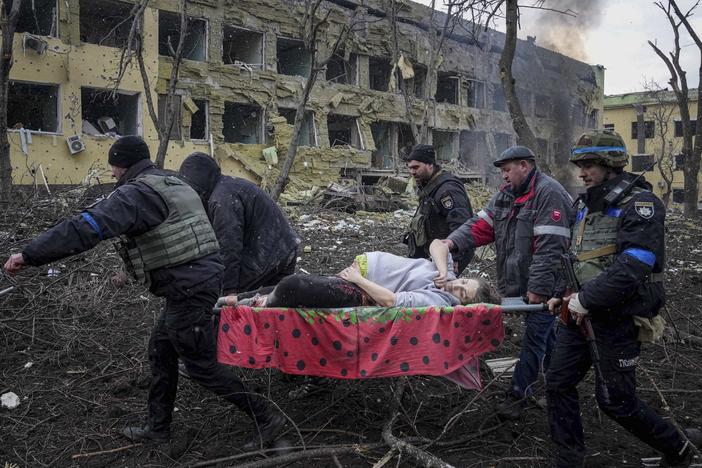 First responders and volunteers carry an injured pregnant woman from a maternity hospital that was damaged by shelling in Mariupol, Ukraine, on Wednesday. The woman and her baby have since died.
