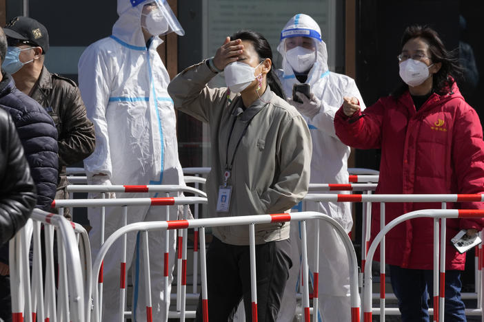 Workers line up for COVID test outside an office building on Monday in Beijing.