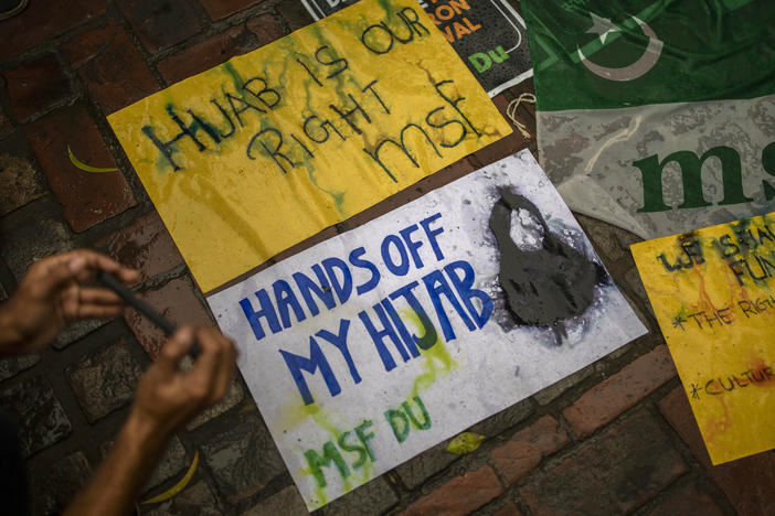 A student takes photographs of placards during a protest against banning Muslim girls from wearing the hijab in educational institutions in the southern Indian state of Karnataka, in New Delhi on Feb. 8, 2022.