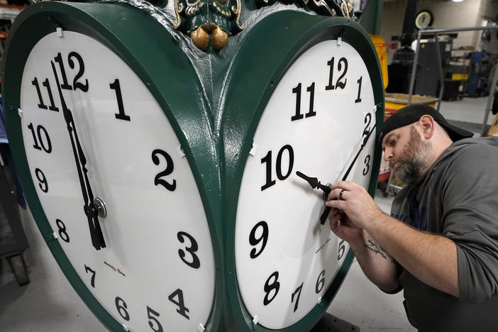 A clock technician adjusts the hands on a large outdoor clock under construction at Electric Time Company in Medfield, Mass, last year, just days before daylight saving time was set to end.