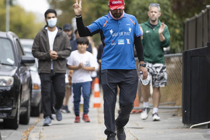 Al Noor Mosque shooting survivor Temel Atacocugu gestures as he completes his walk from Dunedin to Christchurch on the third anniversary of the shootings in Christchurch, New Zealand, on Tuesday.