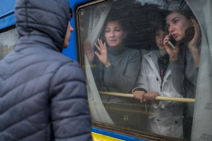 A family in an evacuation train says goodbye to a young man at the central train station in the southern city of Odessa. Russian forces have made progress in the south, overrunning the city of Kherson.