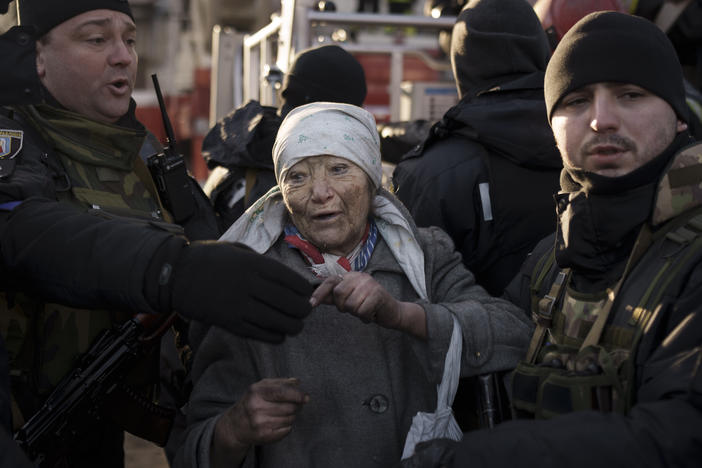 An elderly woman is helped by policemen after she was rescued by firefighters from inside her apartment after bombing in Kyiv, Ukraine, on Tuesday.