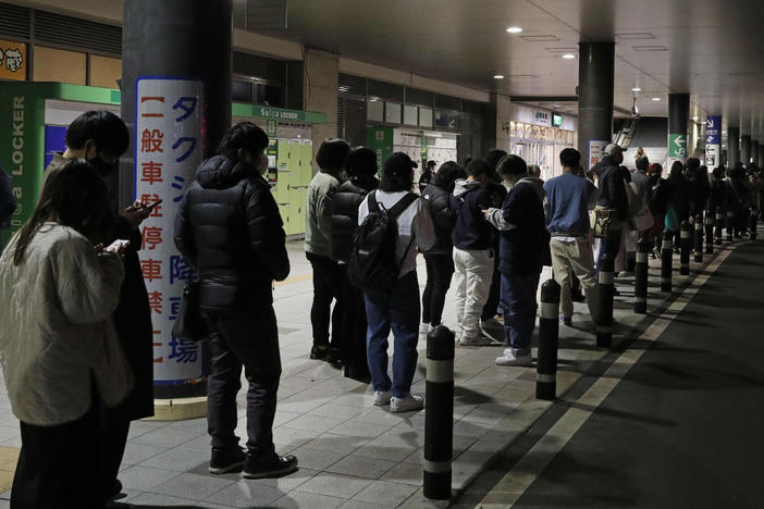 People wait in line for taxis in Sendai, Miyagi prefecture, northern Japan, early Thursday following a powerful earthquake that struck off the coast of Fukushima.