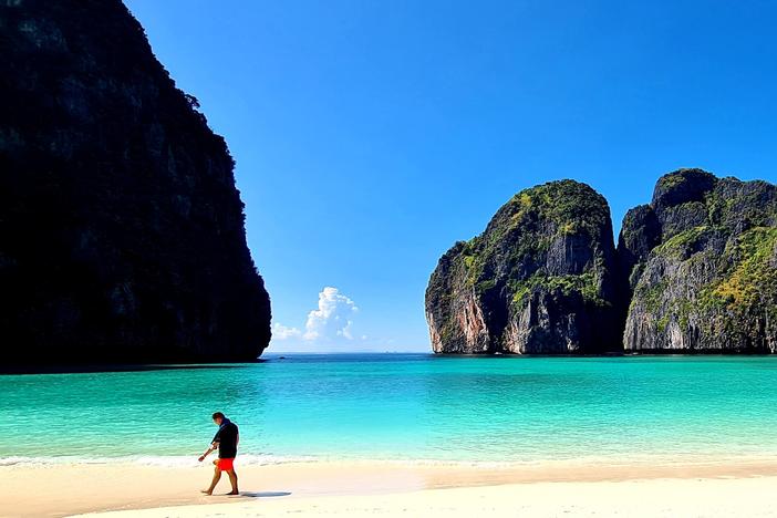 A tourist strolls along the white sand of Maya Beach in Thailand. The destination was once overrun by visitors, but thanks in part to the pandemic, its ecosystem has had time to recover.