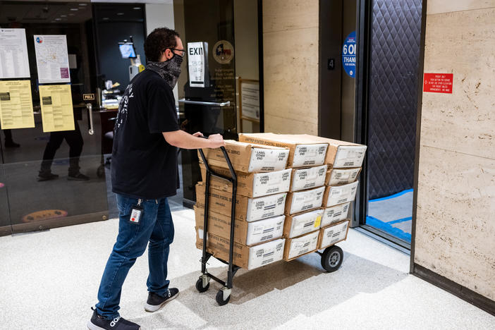 In February, ahead of the Texas statewide primary, Carlos Vanegas at the Harris County Elections Office in Houston pushes a cart with mail-in ballots to be sent to voters. The county ultimately rejected thousands of the mail ballots it received back.