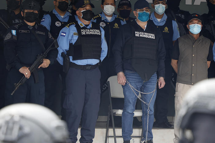 Former Honduran President Juan Orlando Hernandez, center in chains, is shown to the press at the police headquarters in Tegucigalpa, Honduras on Feb. 15, 2022.