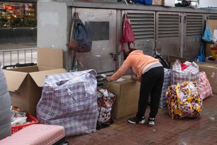 This photo taken on Feb. 20 shows a foreign worker in Hong Kong sheltering with her belongings during the city's current coronavirus surge.