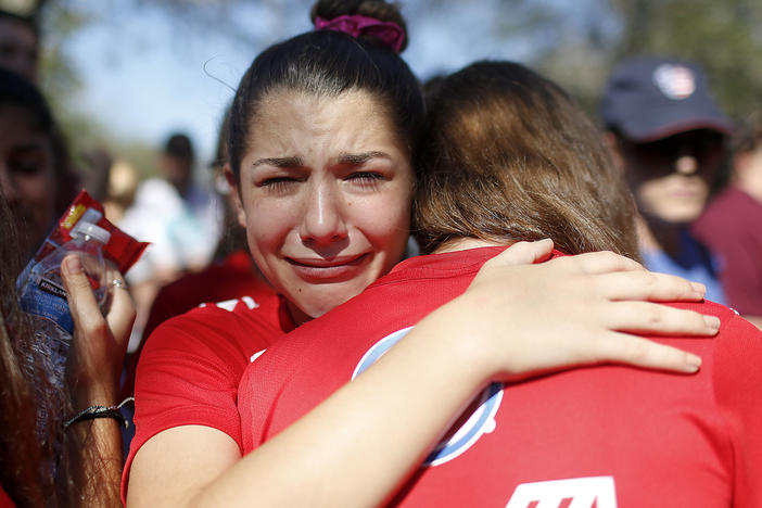 A student mourns the loss of her friend during a community vigil at Pine Trails Park on Feb. 15, 2018, in Parkland, Fla.