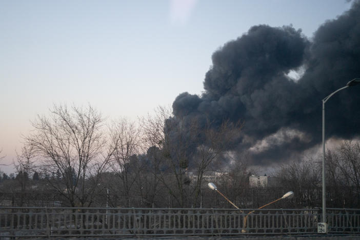 Smoke billows over a street near the airport in Lviv after Russian airstrikes hit a jet repair facility.