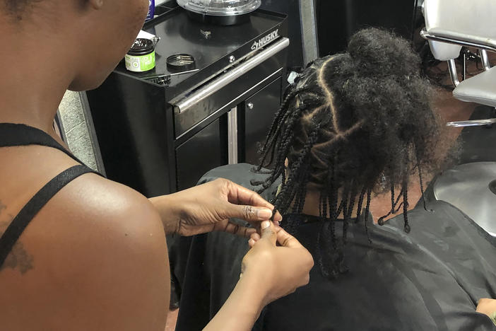 Shana Bonner, left, styles the hair of Pho Gibson at Exquisite U hair salon in this July 3, 2019, file photo. The U.S. House passed a federal anti-bias bill to protect against discrimination of race-based hairstyles.