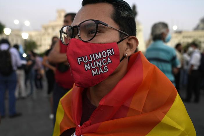 A young man wears a mask protecting against COVID-19 that reads in Spanish "Fujimori never more," as demonstrators protest against the decision of Peru's Constitutional Court approving the release from prison of former President Alberto Fujimori in Lima, Peru on Thursday.