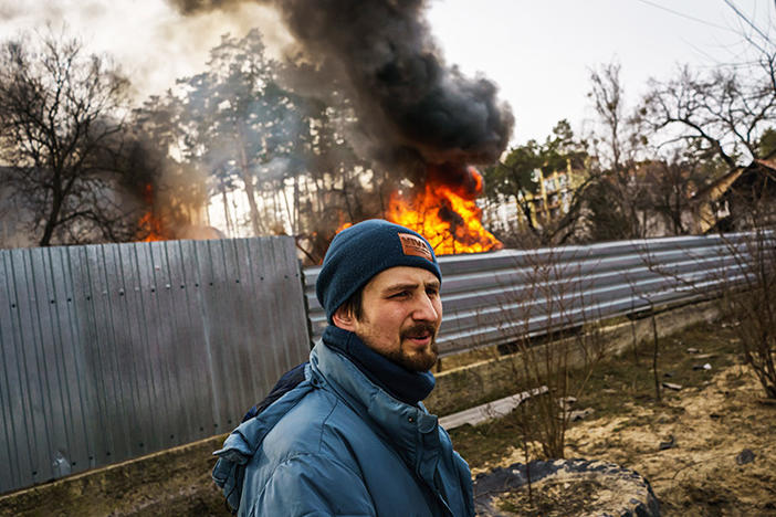 Maksim Chepchenko near a burning home in in Irpin, Ukraine, after Russian bombings on Saturday.