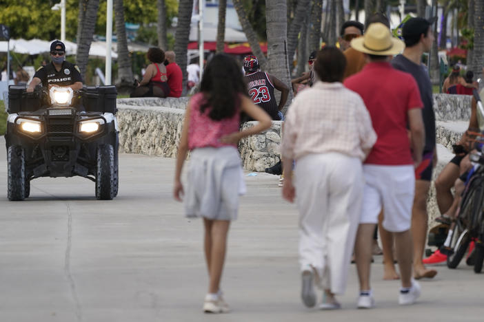 A police officer on an ATV patrols in Miami Beach, Fla.'s famed South Beach in March 2021. City of Miami Beach officials declared a state of emergency on Monday, and an upcoming curfew, bidding to curb violent incidents at spring break that saw five people wounded in two separate shootings.