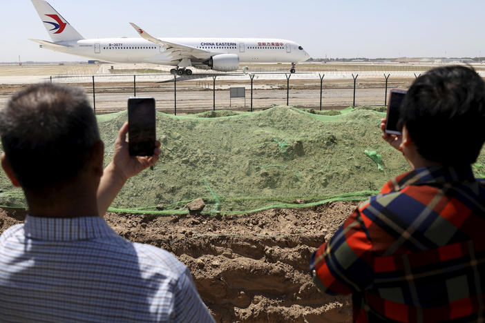 In May 2019, residents watch as a China Eastern passenger jet prepares to take off on a test flight from the new Beijing Daxing International Airport. State media are reporting a Chinese airliner from China Eastern with 132 people on board crashed in the southern province of Guangxi on Monday.