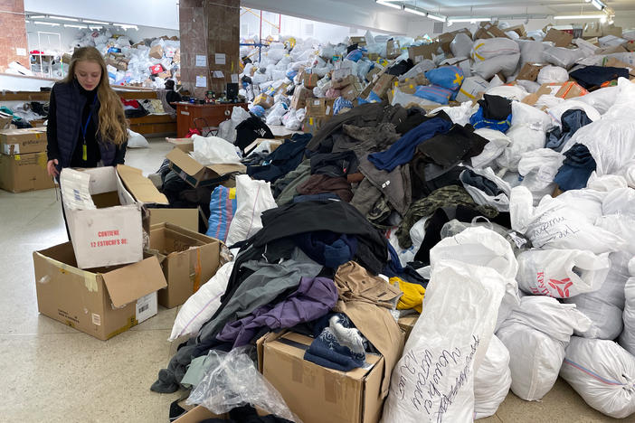 Nastia Stefanovich, a volunteer at the distribution center in Lviv for goods donated for Ukrainians in need, points out the piles of clothes that have been arriving.