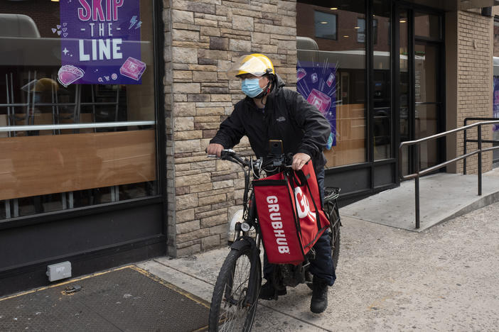 In this April 21, 2021, file photo, a delivery man bikes with a food bag from Grubhub in New York. The three biggest food delivery companies, DoorDash, Grubhub and Uber Eats, sued the City of New York in 2021 over its law to permanently limit the amount they can charge restaurants that use their services.