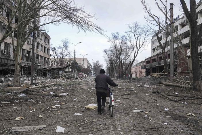 A man walks with a bicycle on a street damaged by shelling in Mariupol, Ukraine, earlier this month.