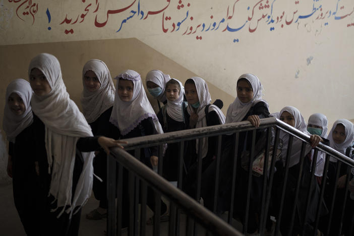Girls enter a school before class in Kabul on Sept. 12, 2021. In a surprise decision, the hardline leadership of Afghanistan's new rulers has decided against opening educational institutions to girls beyond sixth grade.