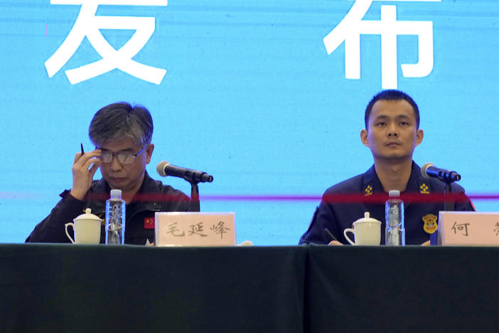 Mao Yanfeng, the director of the accident investigation division of the Civil Aviation Authority of China (left), and He Rong from the Guangxi Fire and Rescue Force attend a press conference in Wuzhou city on Wednesday in southwestern China's Guangxi province. China says one of two so-called black boxes from Monday's plane crash was found in severely damaged condition.