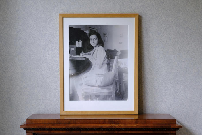 A photo of Anne Frank stands on a replica of the writing desk she once used in her family's former apartment in Amsterdam, during an event to mark what would have been Anne Frank's 90th birthday, in Amsterdam in June 2019.