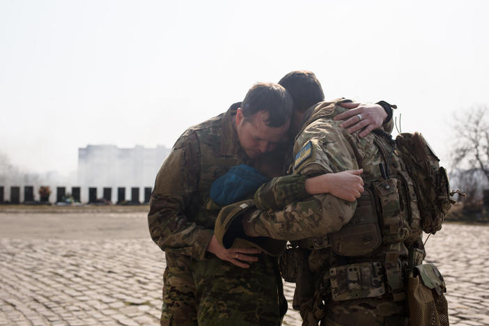 Ukrainian servicemen comfort Daniil, 12, the son of Vladyslav Buvalkin, 42, who died in action and was buried on Wednesday in Kyiv, Ukraine. Ukrainian forces have managed to fend off Russian advances near the capital, although shellfire and aerial bombardment persist.