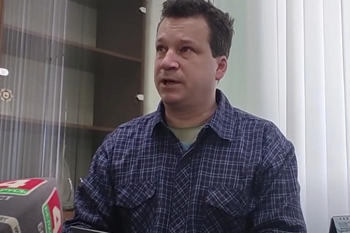 Evan Neumann, who is wanted by the FBI, holds his new Belarusian documents at the department of citizenship and migration office in Brest, Belarus.