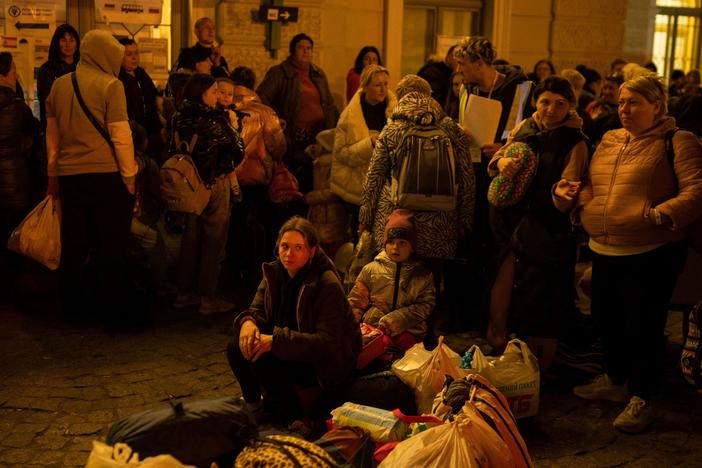 Refugees from Ukraine wait to get on buses to other destinations in Poland, outside the train station in Przemysl, near the Ukrainian-Polish border in southeastern Poland, on Wednesday.