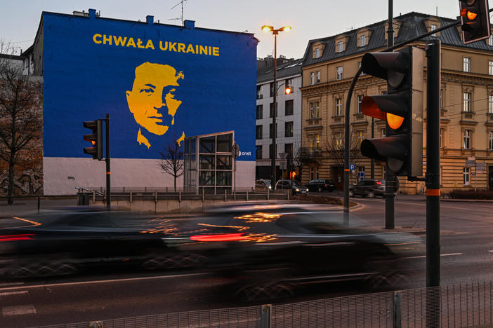 Cars drive past a mural of Ukrainian President Volodymyr Zelenskyy in Krakow, Poland. More than 3 million people have fled Ukraine since Russia's invasion of that country began in February — many have ended up in Poland.