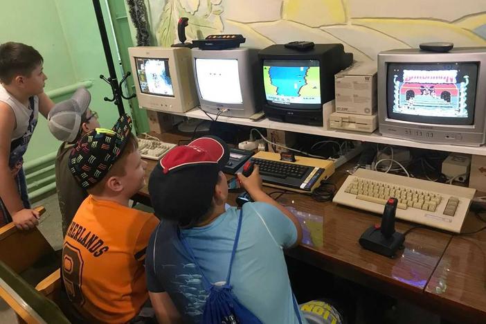 Kids play on retro computers in the IT 8-bit museum in Mariupol, Ukraine before it was attacked.