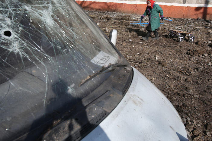 An elderly woman walks with a cart March 14 in a residential area damaged in what is said was an explosion of a ballistic missile in Kramatorsk, Ukraine, in the northern part of the Donetsk oblast.