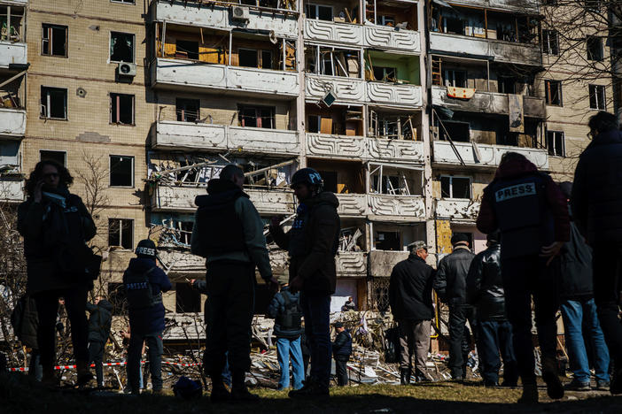 Reporters and residents stand outside a residential building that was damaged by what authorities say is a Russian bombardment in the Vynogradir district of Kyiv, Ukraine on  March 15. Some Ukrainian journalists have been detained and held hostage in Russian-occupied areas of the country.